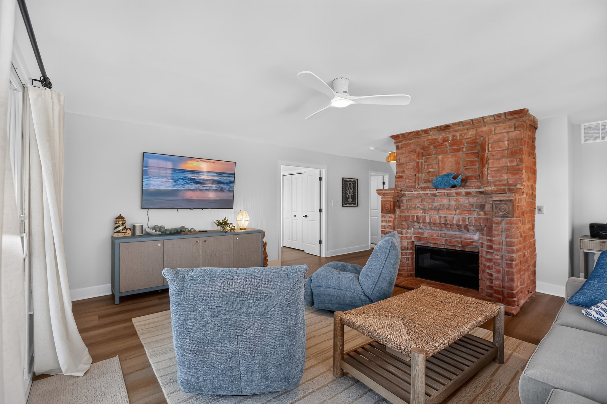 Coastal living room with brick fireplace and TV