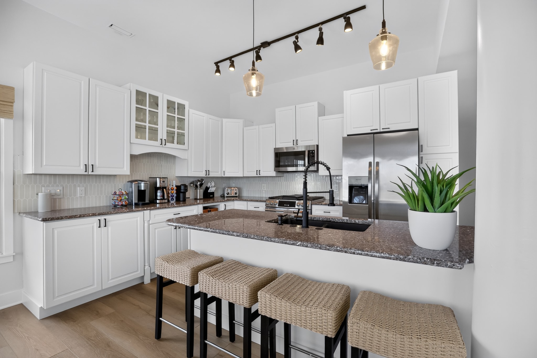 White kitchen with bar seating and stainless appliances