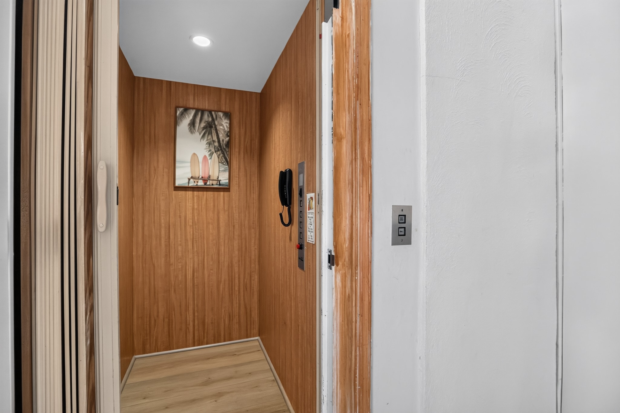 Private in-home elevator with wood paneling and surf art