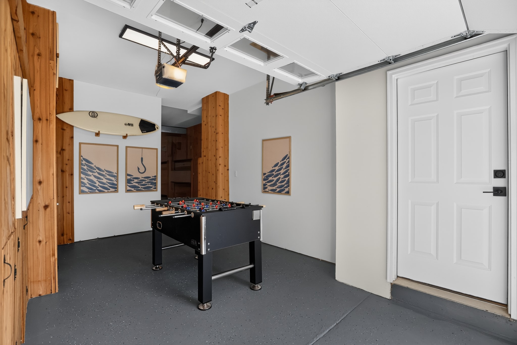 Game room with foosball table, surfboard and nautical decor