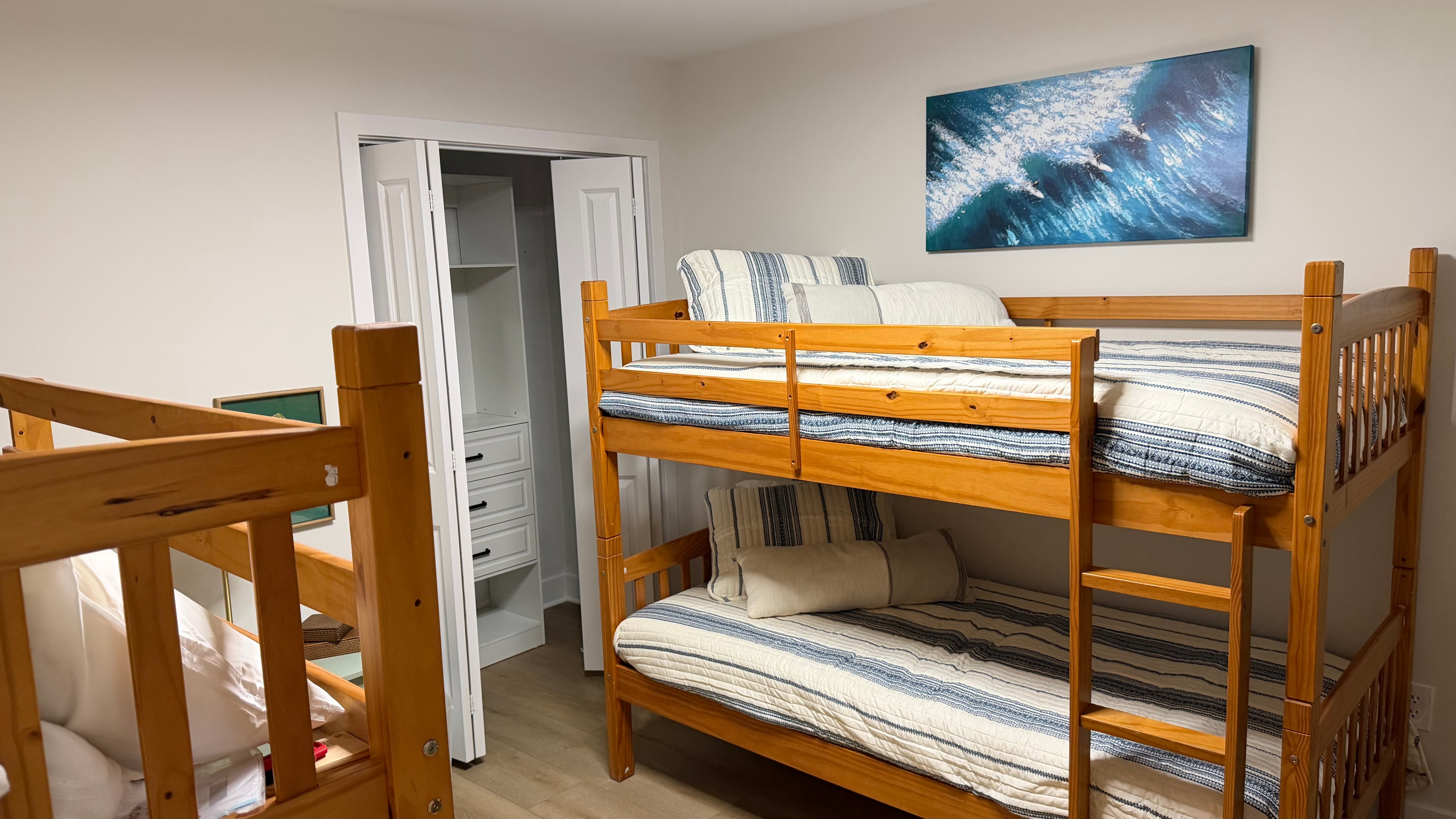 Bunk bed room with two sets of bunk beds and coastal wave art